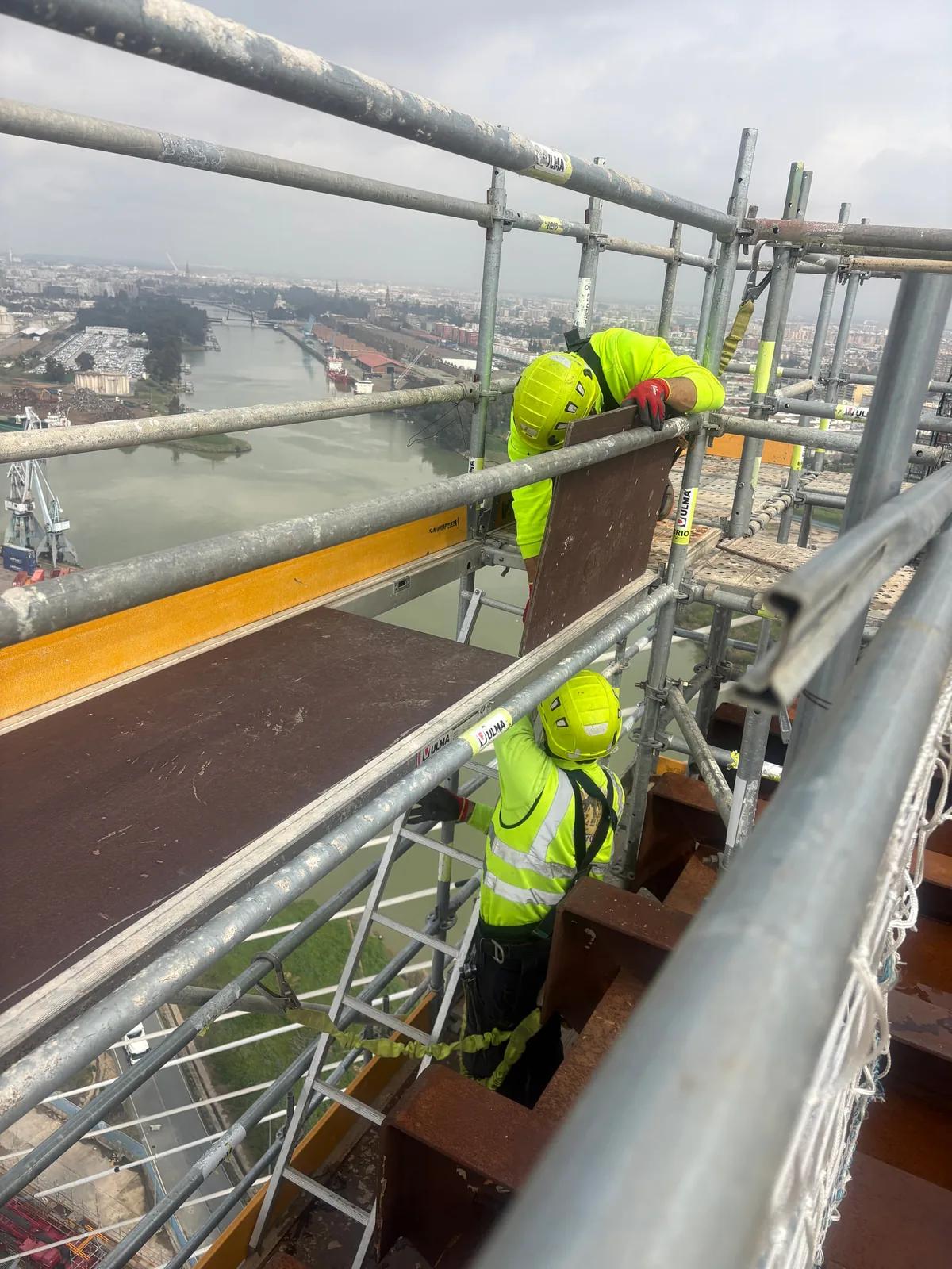 Trabajadores con equipos de protección en una estructura de obra